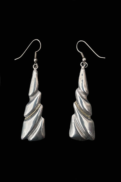Vertical front view of 1980s vintage Taxco two-tone 925 sterling silver and brass triangular fish hook pierced drop earrings.
