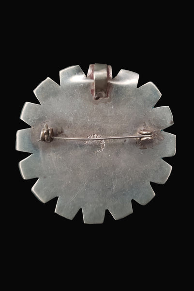 Vertical back view of 1960s vintage round silver and turquoise enamel upside down man in bird costume brooch/pendant. Hecho en Mexico.