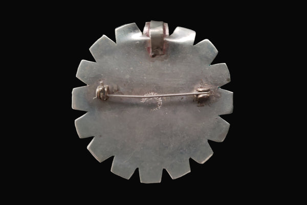 Horizontal back view of 1960s vintage round silver and turquoise enamel upside down man in bird costume brooch/pendant. Hecho en Mexico.