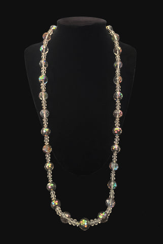 Vertical view of 1980s vintage iridescent gray and clear crystal long beaded necklace. Showing the necklace on a display stand.