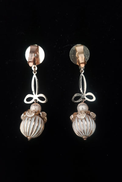 Vertical back view of 1960s vintage champagne gold metal and white painted beaded drop clip-on earrings by Globus.