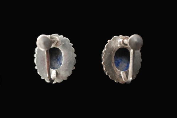 Horizontal back view of 1950s vintage blue lapis lazuli oval cabochon and silver filigree screwback earrings.