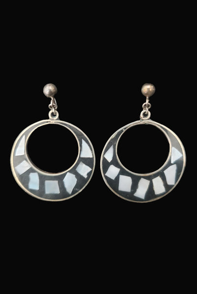 Vertical front view of 1950s vintage alpaca silver and white abalone shell inlaid in black drop hoop screw back earrings.