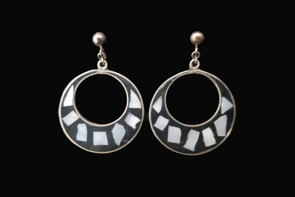 Horizontal front view of 1950s vintage alpaca silver and white abalone shell inlaid in black drop hoop screw back earrings.