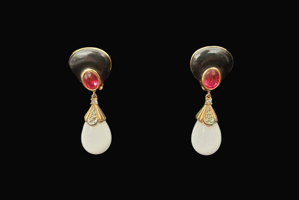 Horizontal front view of 1980s vintage black enamel, oval pink rhinestones, clear rhinestones, white plastic drop, and gold tone metal pierced lever back earrings, by Nina Ricci.