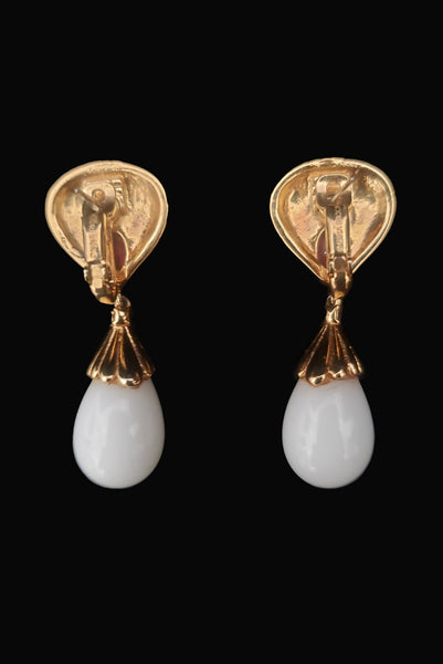 Vertical back view of 1980s vintage black enamel, oval pink rhinestones, clear rhinestones, white plastic drop, and gold tone metal pierced lever back earrings, by Nina Ricci.