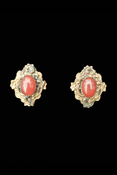 Vertical front view of 1940s vintage rust carnelian oval cabochon in a brass filigree setting unpierced screw back earrings.