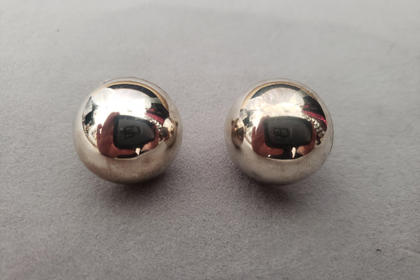 Horizontal front view of 1950s vintage 925 sterling silver ball half round screw back earrings.