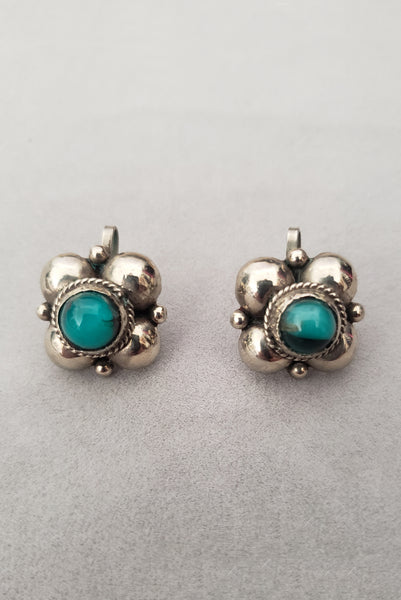 Vertical front view of 1940s vintage 925 sterling silver and turquoise blue round glass cabochon screw back earrings.
