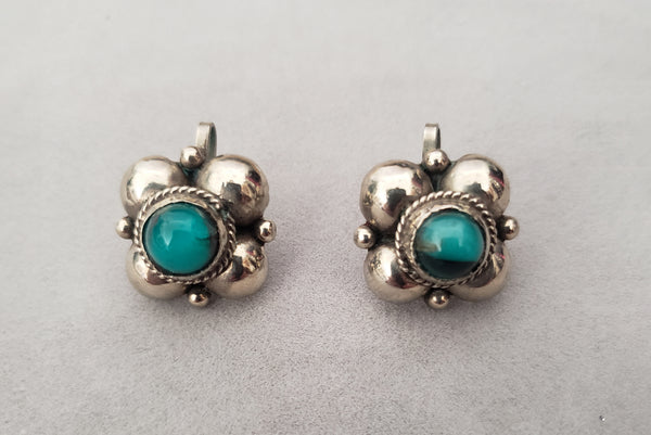 Horizontal front view of 1940s vintage 925 sterling silver and turquoise blue round glass cabochon screw back earrings.