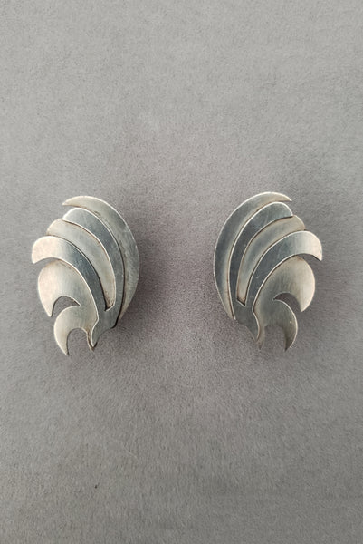 Vertical front view of 1940s vintage 925 sterling silver feather fan screw back earrings.