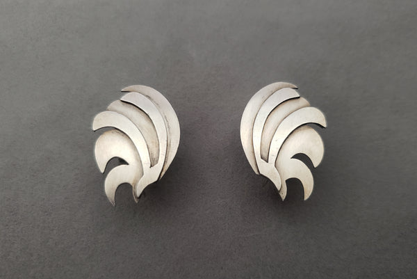 Horizontal perspective view of 1940s vintage 925 sterling silver feather fan screw back earrings.