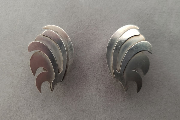 Horizontal front view of 1940s vintage 925 sterling silver feather fan screw back earrings.