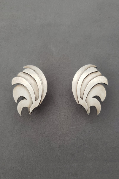Vertical perspective view of 1940s vintage 925 sterling silver feather fan screw back earrings.