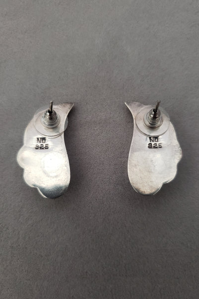 Vertical back view of 1980s vintage 925 sterling silver and marquise onyx cabochon flourish pierced earrings.