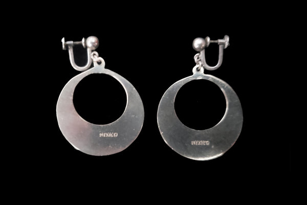 Horizontal back view of 1950s vintage alpaca silver and white abalone shell inlaid in black drop hoop screw back earrings.