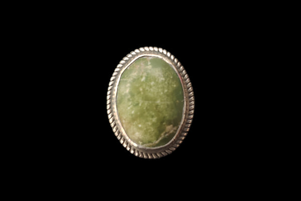 Horizontal front view of 1960s vintage southwestern silver and oval green cabochon mid century ring, size 6.25.