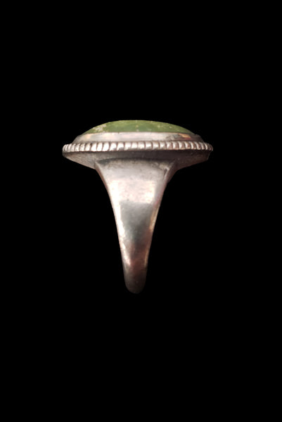 Vertical side view of 1960s vintage southwestern silver and oval green cabochon mid century ring, size 6.25.