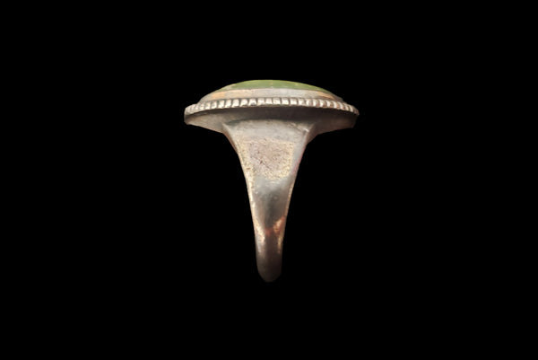 Horizontal side view of 1960s vintage southwestern silver and oval green cabochon mid century ring, size 6.25.