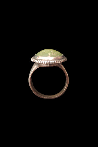 Vertical top view of 1960s vintage southwestern silver and oval green cabochon mid century ring, size 6.25.