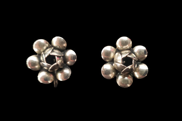 Horizontal front view of 1950s vintage 925 sterling silver floral rose screw back earrings.