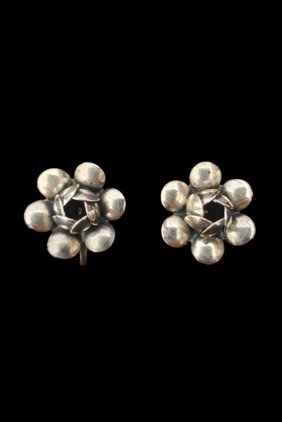 Vertical front view of 1950s vintage 925 sterling silver floral rose screw back earrings.