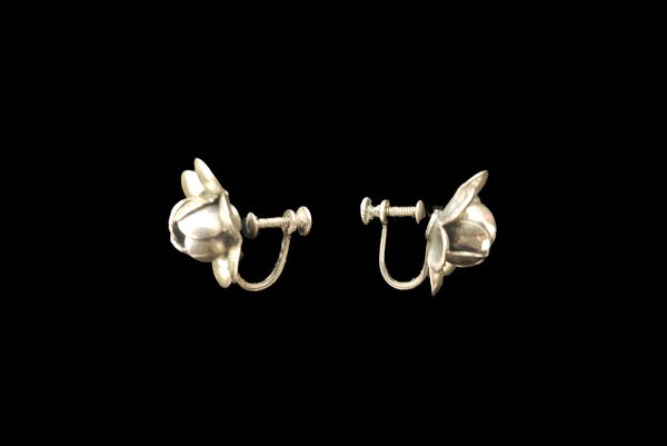 Horizontal side view of 1950s vintage 925 sterling silver floral rose screw back earrings.