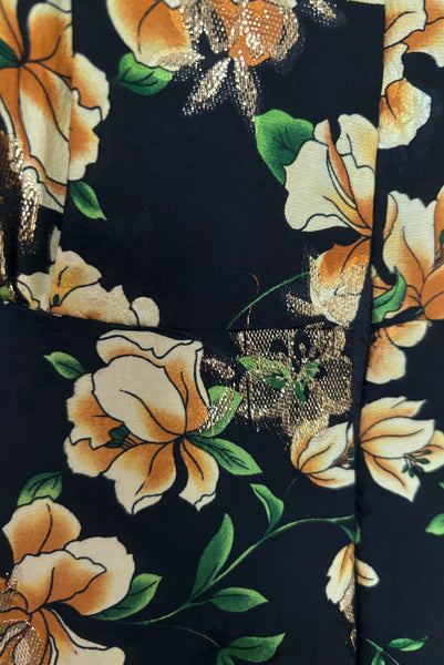 Detail view of vintage 2000s made 1940s reproduction black, yellow, and gold floral silk and lurex evening dress, size medium to large. Showing some pulled lurex threads near the zipper.