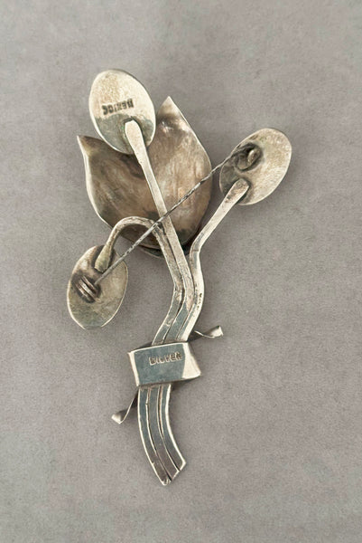 Vertical back view of 1930s vintage Mexican 925 sterling silver flower statement brooch with oval cream cabochon stone.
