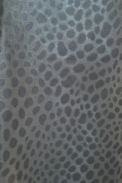 Detail view of 1990s vintage dusty blue polyester jacquard satin bias cut short slip nightgown by Jones New York, size medium to large. Showing the pebble motif satin jacquard.
