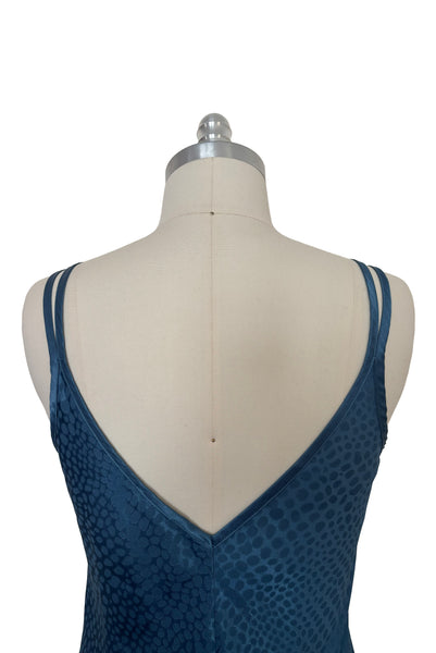 Detail view of 1990s vintage dusty blue polyester jacquard satin bias cut short slip nightgown by Jones New York, size medium to large. Showing the V back neckline and satin double straps.