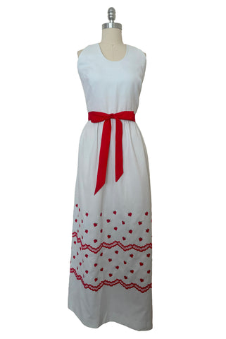 Front view of 1970s white pique halter maxi dress with red strawberry embroidery by Mr. B of California, small to medium. Showing the red grosgrain ribbon at the waist.