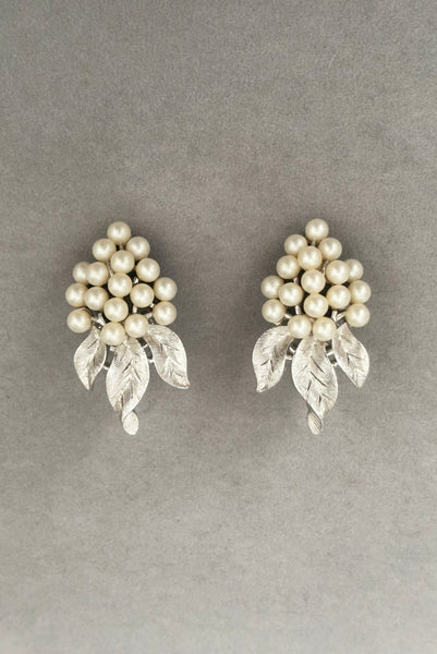 Vertical front view of 1960s vintage Crown Trifari white pearl silver tone grape cluster brooch and clip-on earrings jewelry set. Showing the earrings alone.
