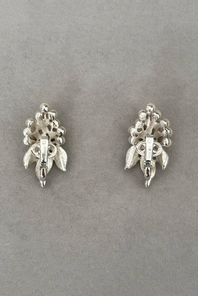 Vertical back view of 1960s vintage Crown Trifari white pearl silver tone grape cluster brooch and clip-on earrings jewelry set. Showing the earrings alone.