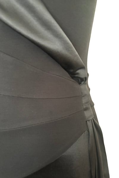 Detail view of 1990s vintage black silk Lycra charmeuse and rayon jersey drop waist halter dress with handkerchief hem by Bebe, size small to medium. Showing the knot detail at the drop waist.