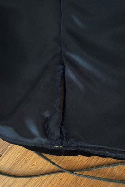 Interior top detail view of 1970s vintage rare designer Holly's Harp black velvet, gold metal cord trimmed wrap top & skirt set, extra small to small. Showing the friction fraying to the satin lining.