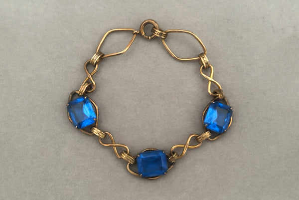 Horizontal front view of 1930s vintage Art Deco blue rhinestone and 12kt gold fill link bracelet.