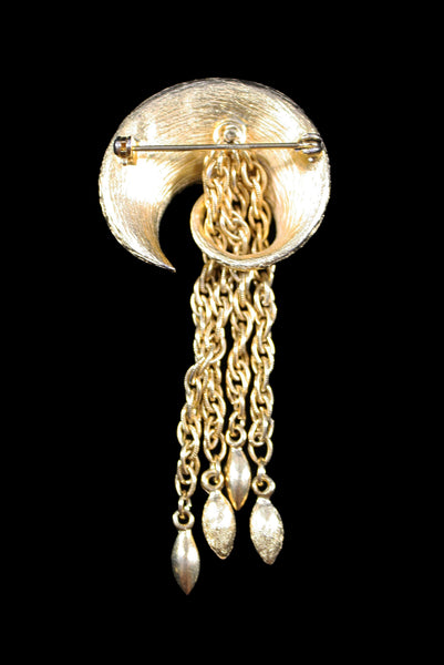 Vertical back view of 1960s vintage round swirl gold tone brooch with chain tassel.