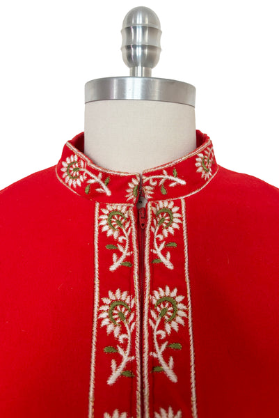 Detail view of 1960s vintage orange fleece, zip front housecoat with white, green, and gold floral embroidery by Evelyn Parsons, size medium to large. Showing the band collar and zipper placket with floral embroidery.