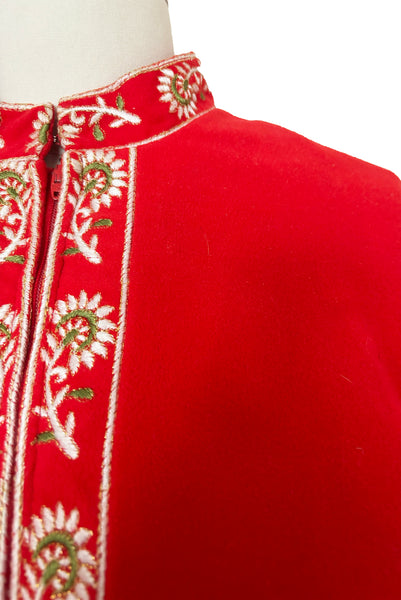 Detail view of 1960s vintage orange fleece, zip front housecoat with white, green, and gold floral embroidery by Evelyn Parsons, size medium to large. Showing the band collar and zipper placket with floral embroidery.