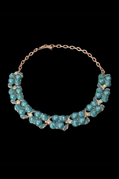 Vertical perspective view of 1950s vintage teal blue textured plastic bead and iridescent rhinestone silver tone necklace.