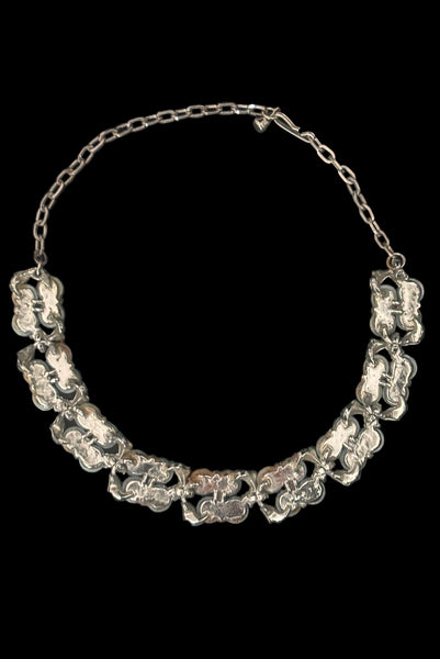 Vertical back view of 1950s vintage teal blue textured plastic bead and iridescent rhinestone silver tone necklace.
