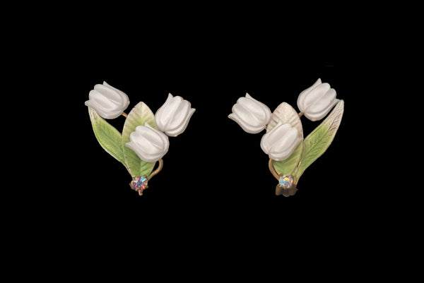 Horizontal front view of 1950s vintage iridescent rhinestone, white plastic tulip, green and white painted floral gold tone metal clip-on earrings.