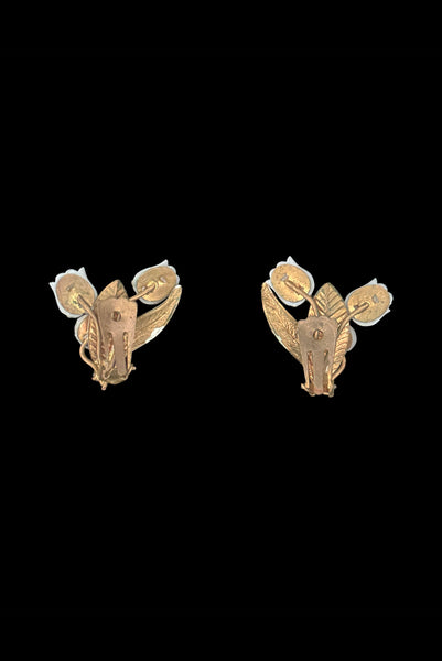 Vertical back view of 1950s vintage iridescent rhinestone, white plastic tulip, green and white painted floral gold tone metal clip-on earrings.