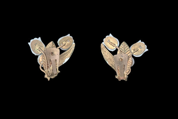Horizontal back view of 1950s vintage iridescent rhinestone, white plastic tulip, green and white painted floral gold tone metal clip-on earrings.