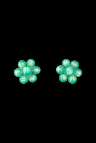 Vertical front view of 1940s vintage green moonglow Lucite bead floral screw back earrings.