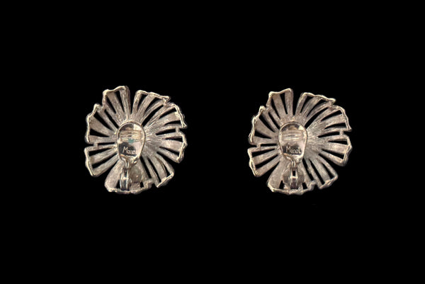 Horizontal back view of 1960s vintage large round gold tone floral clip-on earrings by Monet.
