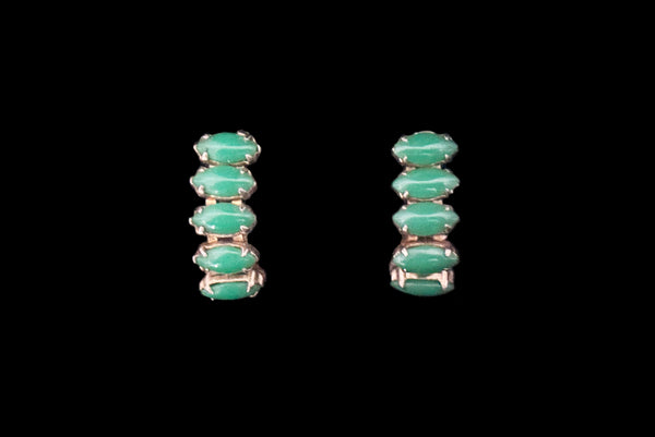 Horizontal front view of 1950s vintage green marquise cabochon gold tone clip -on hoop earrings.