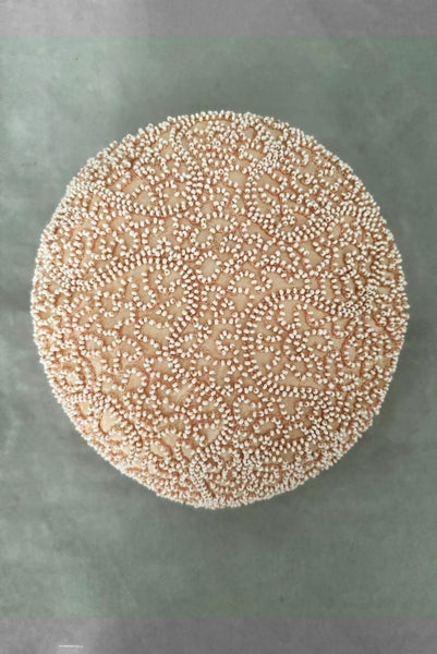 Vertical top view of 1960s vintage blush pink faille fabric pillbox hat covered in matching glass seed beads by Neiman Marcus.