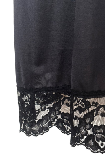Detail view of 1990s vintage black nylon and lace lingerie half slip by Vassarette, size large to extra large. Showing a close-up of the lace hem.